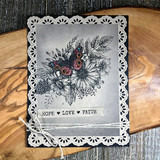 Soft grey card in a white lace doily frame; the floral swag is stamped in black with tiny colored accents above 'HOPE LOVE FAITH.'