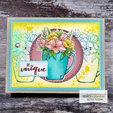 Yellow and teal layered card with a teal mug of pastel pink and yellow blooms inside a mauve circle, a small white tag reading Be unique tucked at the left.