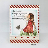 Card of the girl in a red-brown dress over a striped panel with the blessing.