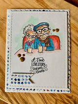 Card on wood grain with the couple colored in teal and red sweaters holding coffee mugs, above script 'A true LOVE STORY never ends' with copper dots.