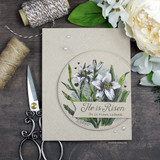 The lily in a stitched circle on a kraft card — 'He is Risen indeed.'
