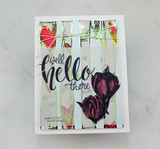 The tulips stamped in deep plum on a card layered over striped and heart papers, reading 'well hello there.'