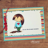 Striped card with the girl colored in a blue heart shirt and green pants on a torn white panel, stamped 'It's ok. We all make mistakes.'