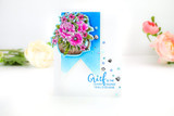 Slim blue card with a footed vase of magenta blooms; the wording shown is from another set.
