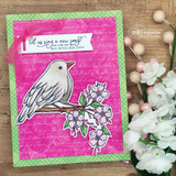 Pink card of the bird on the branch with 'let us sing a new song not with our lips, but with our lives.'