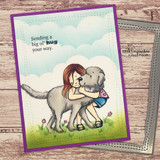 Card with the girl hugging a grey dog against a cloudy blue sky, 'Sending a big ol' hug your way.'