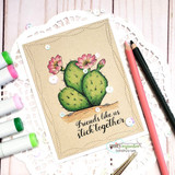 Cactus card on kraft with a doily and coloring markers, 'Friends like us stick together.'