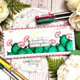 Slimline card with a row of teal cacti and pink blooms, 'Friends like us stick together.'
