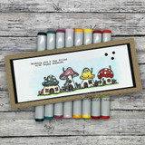 Slimline card with the mushroom houses colored softly, surrounded by gray marker blends.