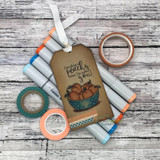 The peach-bowl image on a kraft gift tag tied with ribbon and staged with coordinating markers and washi.