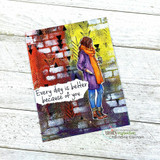 Handmade card featuring the autumn girl bundled in a coat and scarf holding a warm drink, over a brick mixed-media panel, stamped with 'Every day is better because of you'.