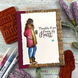 Handmade card featuring the autumn girl bundled in a coat and scarf holding a warm drink, on a soft floral fall background, stamped with 'Every day is better because of you'.