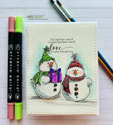 White lined-paper card with the two snowmen colored in green and purple beside blending markers.
