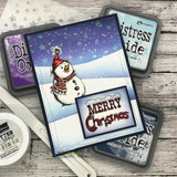 Card of a scarfed snowman on a starry night panel, 'MERRY Christmas' with distress ink pads alongside.