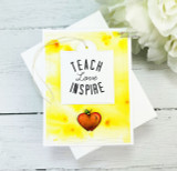 "Teach Love Inspire" tag on a sunny yellow distress-inked card with a single red apple.