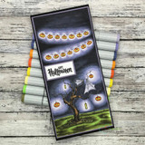 Slimline card with the spooky pumpkin-lit tree over a purple night sky and green grass with 'Happy Halloween.'