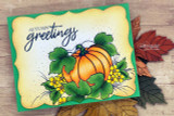 Orange pumpkin and yellow blooms on a green-framed card, 'Autumn greetings'.