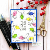 Handmade card featuring the string of vintage Christmas lights framing an A2 card, colored in jewel tones on navy, stamped with 'Wishing you joy'.