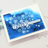Snowflake heart on a blue watercolor sky, 'cheers, holly jolly holiday,' with scattered snowflakes.
