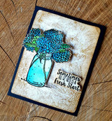 A full-panel daisy background stamped in red rubber and colored on a handmade card reading "Congrats to you."