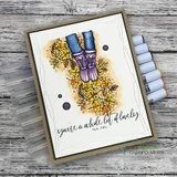 Card of boots in autumn leaves on a soft gray woodgrain background.