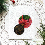 White doily card with a red poinsettia circle and a black circle reading 'Merry & Happy', styled with greenery.