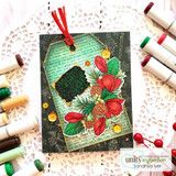 Green tag with a red poinsettia and pine cluster, a black label with a script greeting, and a red ribbon, shown with markers.