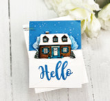 A cozy home framed by snowy evergreens stamped in red rubber and colored on a handmade card reading "May your home be filled with the wonder and joy of the season."
