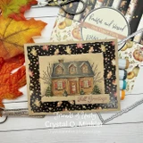 Handmade card featuring a cozy home framed by snowy evergreens, with the sentiment "Warm wishes for your home."
