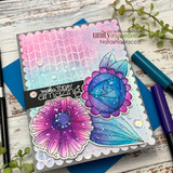 Pink and aqua card with a purple daisy, a blue spiral rose and blue leaves colored with splatter, and a black sentiment strip