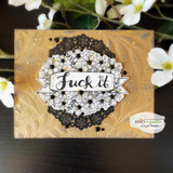 The wreath stamped over a black doily on a golden mixed-media card.