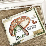 Card with the gnome under a brown mushroom over a burlap panel and 'THE SUN WILL SHINE AGAIN!'