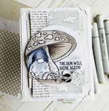 Card with the gnome under a mushroom over dotted papers and 'THE SUN WILL SHINE AGAIN!'