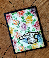 Bright card with the rose pattern stamped in rainbow colors as a full floral backdrop, topped with a 'Smiles are proof of everyday miracles' banner.