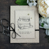 Handmade card featuring a girl holding a tall stack of books, with the sentiment "This is just one chapter, not the end of the story."