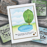 Card with a green tree beside a blue pond, stamped 'Take the moments you need to grow and strengthen your roots.'