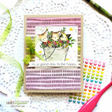 Card on a doily with the dashed background stamped in plum on kraft, layered with a floral cat panel and the sentiment 'it's a good day to be happy'.
