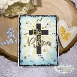Card with a bold solid cross on a blue-grey sunburst and a die-cut 'He is Risen.'