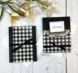 Black gingham card with a slim black bow beside a matching card whose stamped laptop screen reads virtual hugs, styled with pale lilies.