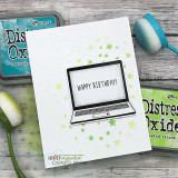 Clean white card with lime green stars blended around a stamped laptop, happy birthday! on its screen, Distress Oxide pads and a blending brush alongside.