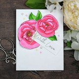 Sample card with two pink blooms and green leaves die cut and layered on a clean white panel, tied with twine and finished with a tag reading 'With Love'.