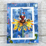 Blue mixed-media card with the gnome colored in red and blue on a yellow daisy, topped with a die-cut 'hello.'