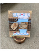 Handmade card featuring the floral and plain to-go coffee cups, on a striped woodgrain panel, stamped with 'Freshly brewed coffee for the soul'.