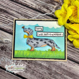 A dappled grey dachshund with a yellow bow tie on a blue-sky and grass scene, captioned 'Sorry, I was such a weenie.'