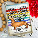 The dachshund colored over rainbow pawprint stripes on a bright card.
