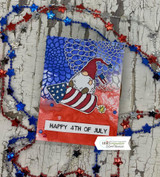Card with the gnome over a blue mosaic background framed by red-white-and-blue star beads.