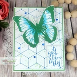 A green framed card with the cube lattice stamped in blue behind a large green and teal butterfly, with a small sentiment tag.
