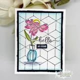 A black bordered card with the cube lattice stamped in grey behind a pink flower in a blue vase, with hello scripted across it.