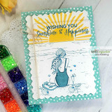 Beach girl in a teal suit below a stamped sunburst, 'Wishing you sunshine & happiness,' on a teal scalloped frame.