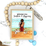 Beach girl in a burgundy suit on sand, 'Wishing you sunshine & happiness,' kraft frame with wood-bead accents.